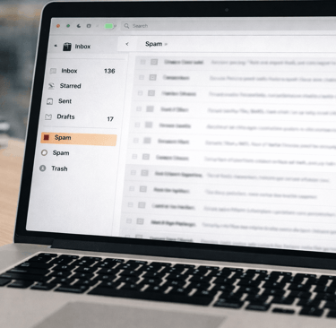 Email spam folder highlighted on a laptop screen in an office setting