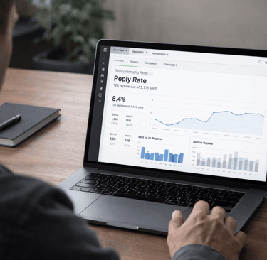 Founder reviewing reply rate analytics dashboard on laptop during cold email campaign analysis