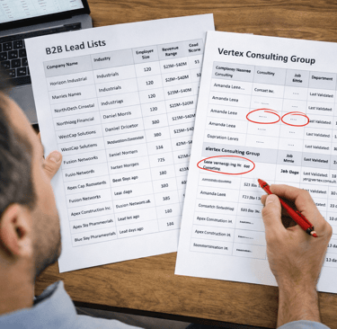 Founder reviewing printed B2B lead list with missing fields circled and lead scores visible