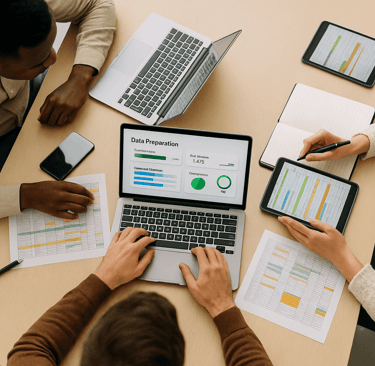Top-down view of a team preparing data on laptops and tablets.