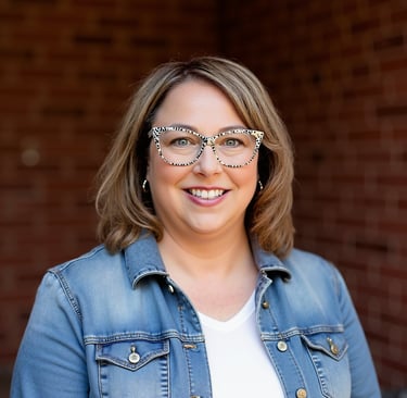 alt="Smiling woman in a jean jacket and white T-shirt"