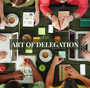 a group of people sitting around a table with laptops