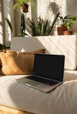 Ordinateur sur canapé illustrant les séances de sophrologie en visioconférence, simples, accessiblel