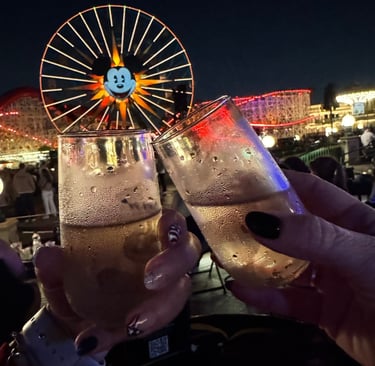 Couple toasting champagne in front of the Mickey Ferris Wheel at Disney California Adventure / night