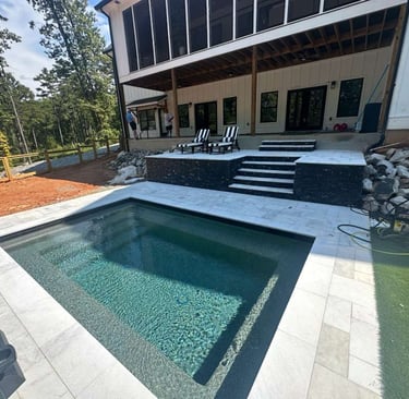 a pool with a deck and a deck with chairs