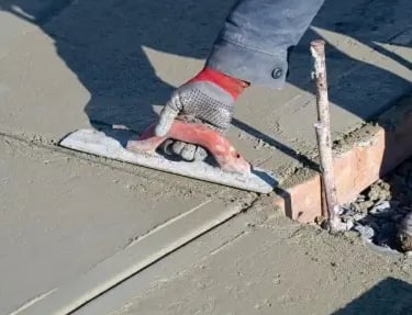 a person is using a cement blocker to make a concrete floor