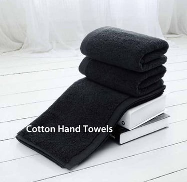 a stack of Cotton hand towels on a white floor