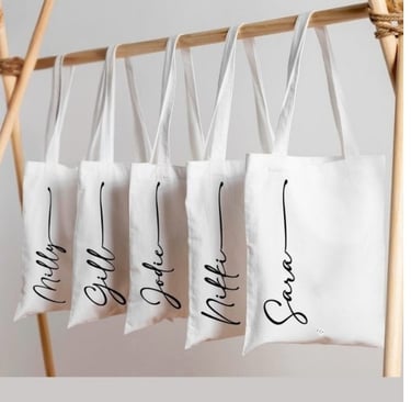 a row of tote bags with customized name 