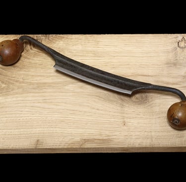 a draw knife and a knife on a wooden table