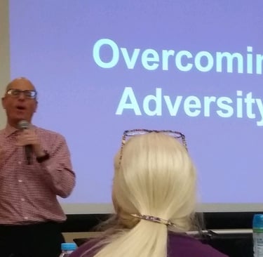 Image is of David D'Arcangelo Speaking in front of a corporate audience talking about disability inc