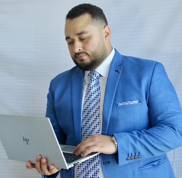 a man in a blue suit and tie is holding a laptop