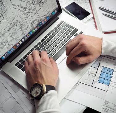 Homem trabalhando em um laptop, simbolizando planejamento e execução de projeto.