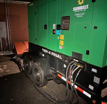 A Sunbelt Rentals Tier 4 Final industrial generator trailer providing emergency power with heavy-duty cables attached.