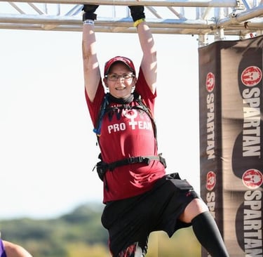 Elizabeth from WOR on monkey bars at Spartan Race