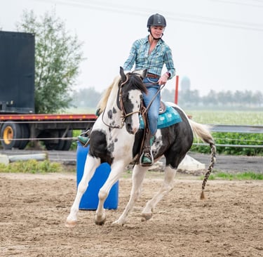 Cowgirl die op een zwart wit paard rijdt