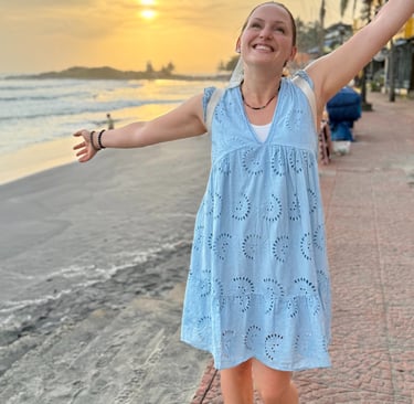 Alena Booth smiling with her hands wide open happy to be in India and seeing the sunset
