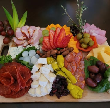 Gourmet cheese and charcuterie grazing board featuring fresh herb and strawberry garnishes for events in Aurora.