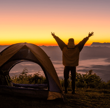 A person camping at sunset in Colorado, joyful about being free from chronic pain