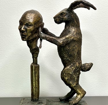 a bronze sculpture of a rabbit carving a human head