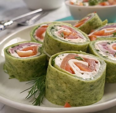 a plate of food that includes salmon, cucumber, cream cheese, pinwheels
