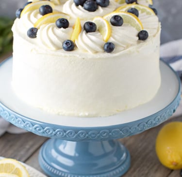 a cake with lemons and blueberries on a blue plate