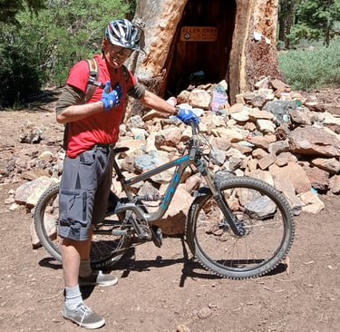 Mountain biker standing next to bike giving thumbs up sign wearing mtb gloves