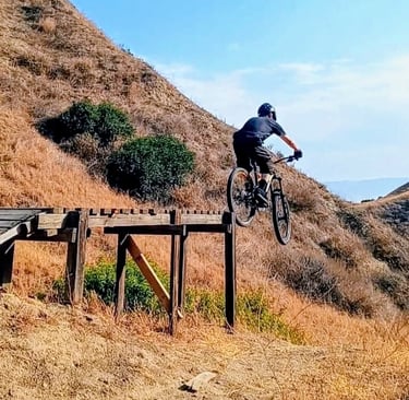 mountain biker riding off ladder drop