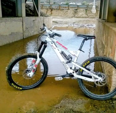 Mountain bike with Maxxis tires parked in flooded wash after winter storm in Southern California