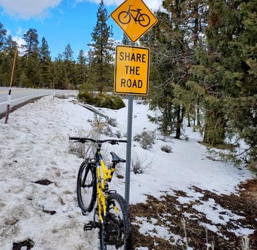 Mountain bike leaning against share the road sign in snowy Big Bear California