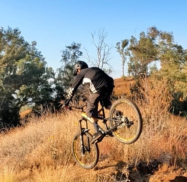 Mountain biker pitched forward and nose heavy on a jump landing, risk of front wheel dive