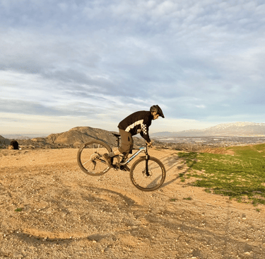 rider doing a rear wheel lift with flat pedals on a mountain bike