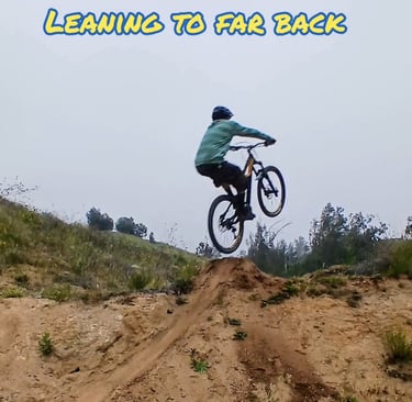 Mountain biker leaning too far back off the takeoff, front wheel rising too high