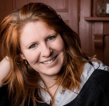 a woman with red hair and a black sweater