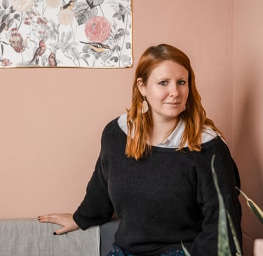 Femme assise sur un canapé face à l'objectif