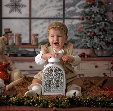 bebé sonriendo en un fondo de navidad con una lámpara entre las piernas