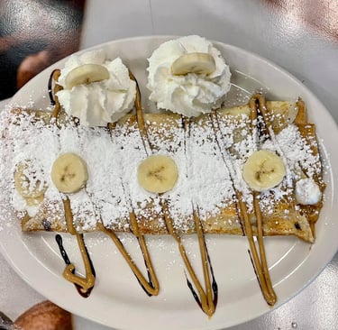 a plate of food with bananas and whipped cream