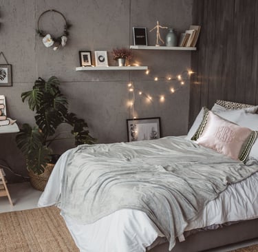 a bedroom with a bed and a desk with a lamp