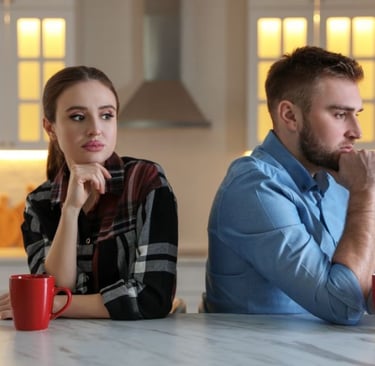 a man and woman sitting at a table avoiding talking