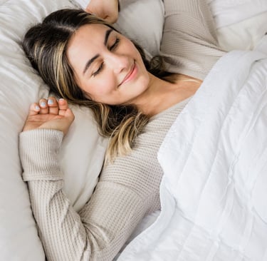 a woman laying on a bed with her eyes closed