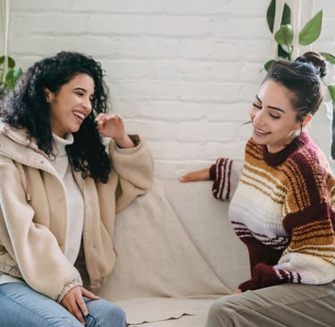 two women sitting on a couch in a living room