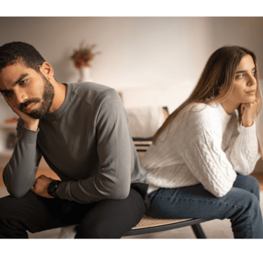 a man and woman sitting on a bench in a living room