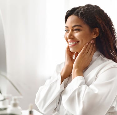 a woman in a white robe is smiling and holding her hands up to her chin
