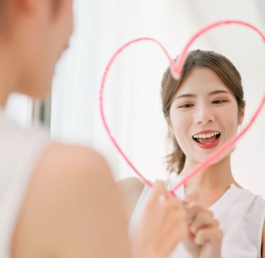 a woman drawing a heart on a mirror