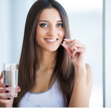 a woman holding a glass of water and a pill pill