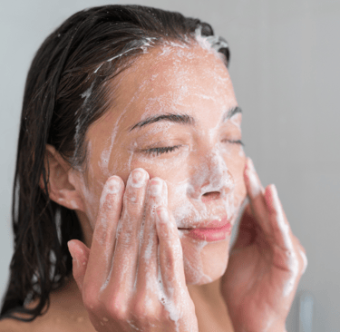 woman exfoliating her face