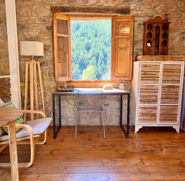 Escritorio junto a la ventana con vistas a la montaña en La Calma, casa rural en Fuentes de Ayódar