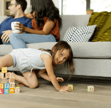 a young girl playing with blocks on the floor