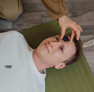 Un hombre acostado recibiendo energía mediante un cristal