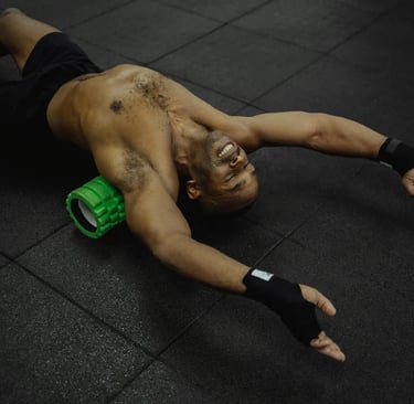 Man lying on a foam roller performing back and muscle release exercises to improve mobility and reco