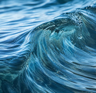 Close-up of a blue ocean wave curling with textured water ripples and sunlight reflections.